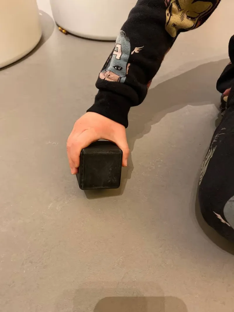 A picture of a kid holding one of the testing box sizes, size 6cm.