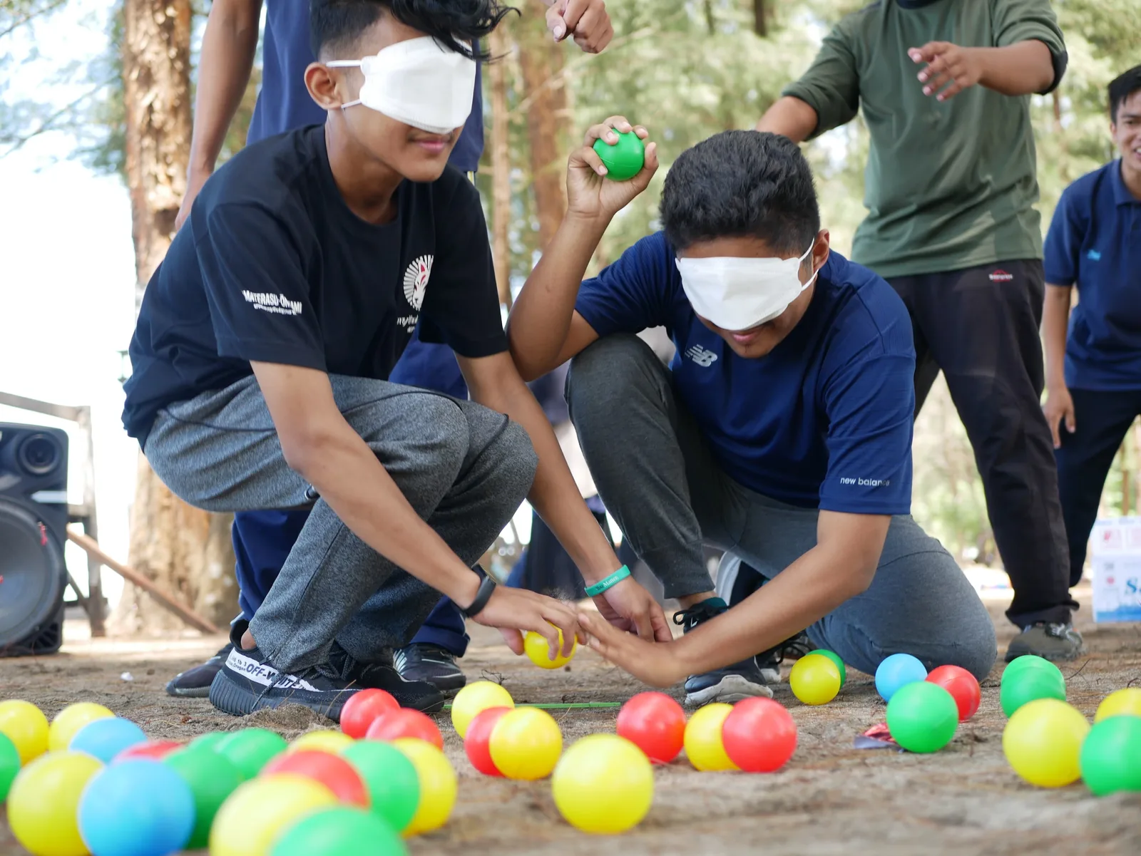 A photo of two teenagers playing outside and having blindfolds on.