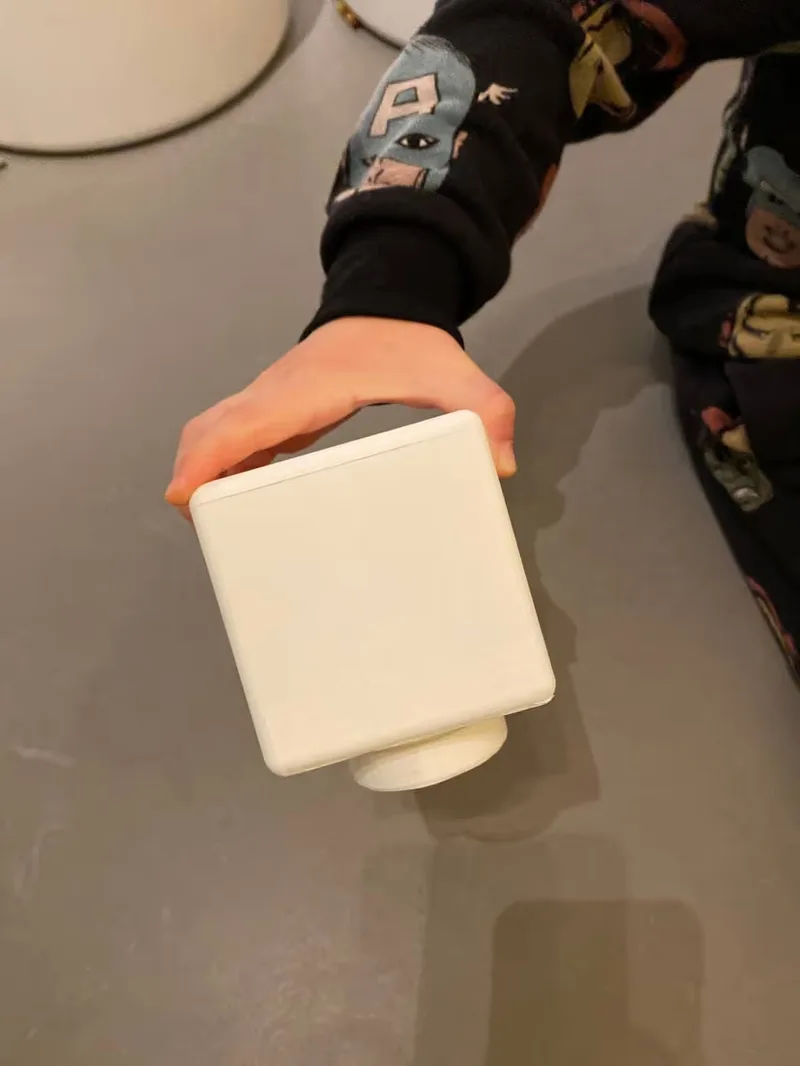 A picture of a kid holding one of the testing box sizes, size 9cm.