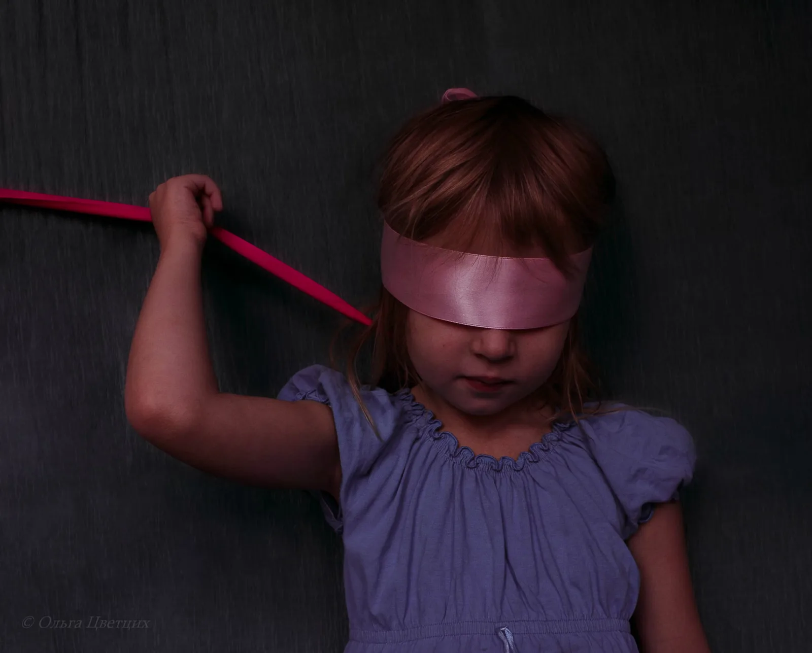 A photo of a child with a blindfold, illustrating how they might feel darkness.