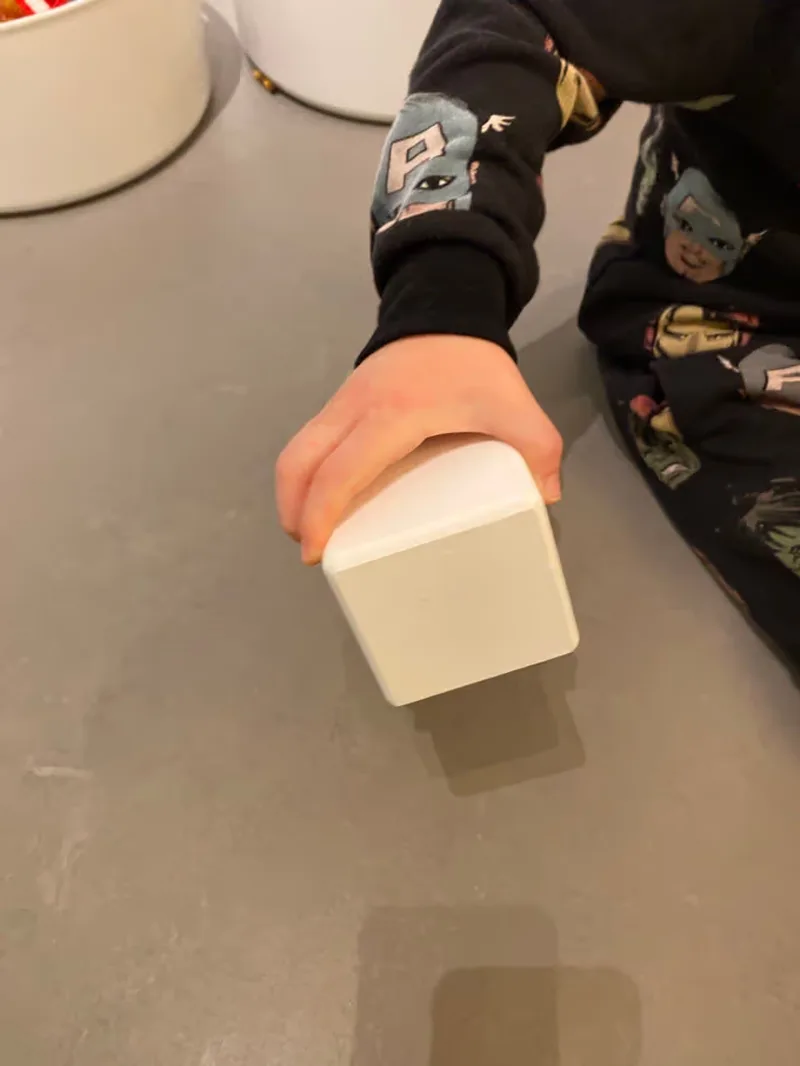 A picture of a kid holding one of the testing box sizes, size 7cm.