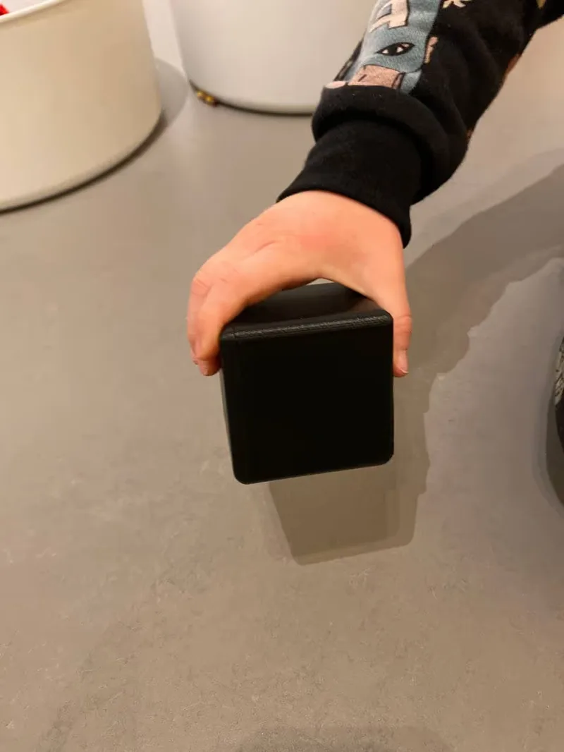 A picture of a kid holding one of the testing box sizes, size 8cm.